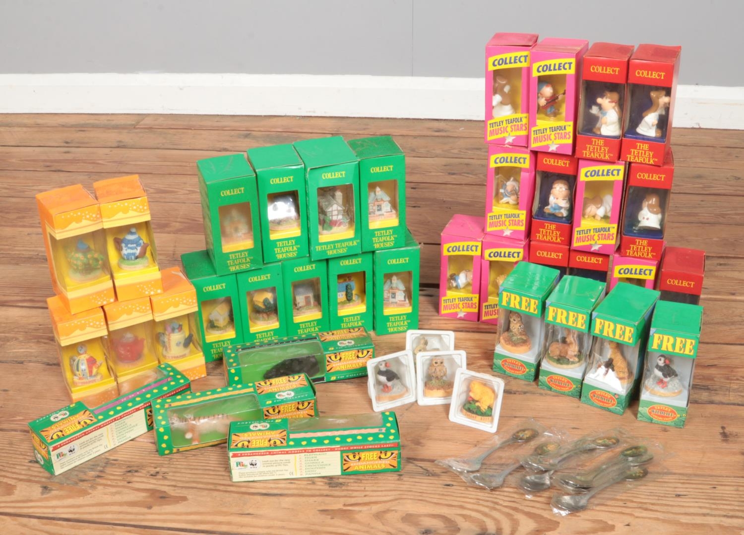 A box of Tetley tea and PG Tips collectables. Includes spoons, Tea Folk, Tea Folk houses,