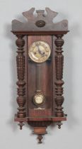 A mahogany wall clock with enamel face, turned columns and carved detail. Hx86cm approx