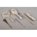 A three piece silver filled dressing table set; having scrolled and masked decoration, together with