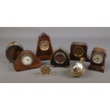 A large collection of small clocks including several mantel clocks, bullseye clock, services