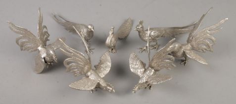 A collection of white metal peacocks and fighting cocks. Includes two examples stamped Italy to