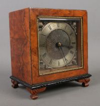 A burr walnut mantel clock of square form with engraved dial with roman numeral markers behind a