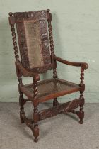 A profusely carved Victorian oak elbow chair with bergere seat and back. Hx118cm