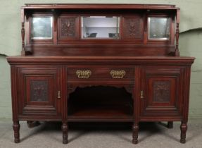 An early 20th century mirror back sideboard with central drawers above dog kennel storage area and