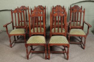 A set of ten oak dining chairs, containing two carvers. Featuring carved detailing to top of