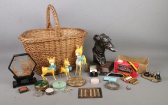 A wicker basket containing an assortment of collectables, to include bronzed greyhound face on bust,