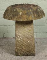 A hand carved stone saddle stone with scooped top Hx48cm