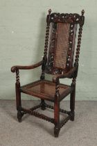 A profusely carved Victorian oak elbow chair with bergere seat and back. Hx135cm