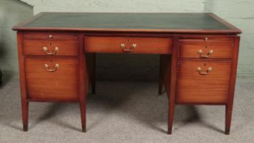 A quality mahogany twin pedestal desk with leather inset top and brushing slides stood on brass