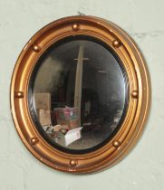 A circular gilt framed convex mirror. Diameter: 34cm.