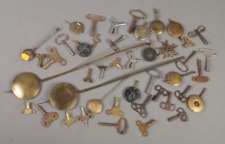 A collection of clock keys, pocket watch keys and pendulums.