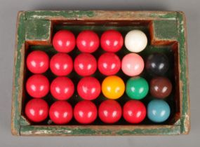 A full set of vintage snooker balls in wooden tray.