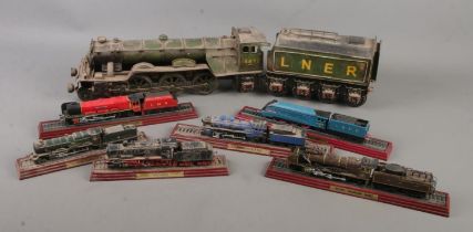 A collection of model trains; tin plate Flying Scotsman and six examples on wooden stands, including