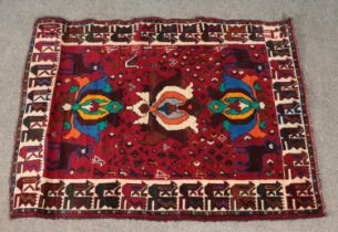 An Eastern red ground wool rug. 165cm x 130cm.