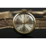 A ladies 9ct Gold Tissot manual wind wristwatch. With silvered dial and baton markers. Stamped to