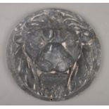 A circular cast iron lion mask plaque. Diameter 30cm.