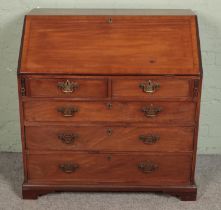 A large mahogany four drawer bureau with brass escutcheons and handles with fitted interior and