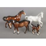 Four Beswick horses including trotting Dapple and foal examples. All have been previously repaired