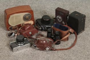 A collection of vintage cameras including Koura, Ricoh and kodak examples with a set of binoculars