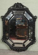 A large octagonal cushion frame mirror surmounted with scrolling acanthus design. Hx157cm Wx114cm