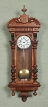 A walnut Vienna style wall clock, with Roman Numeral dial and carved detailing. Chiming on a