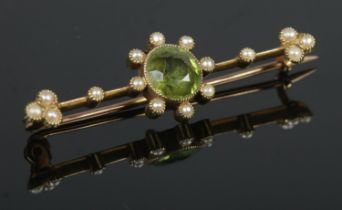 A 15ct Gold brooch, set with with central faceted peridot stone surrounded by seed pearls. Total