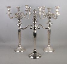 Three chromed four-branch candelabra.