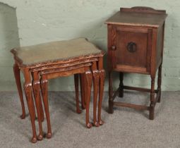 A nest of three tables with walnut quarter veneer tops along with oak pot cupboard