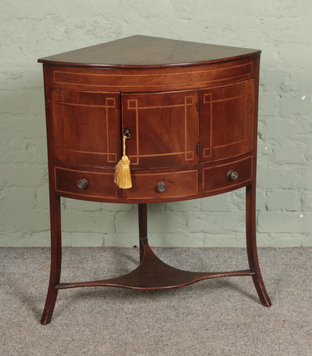 A Victorian mahogany inlaid corner wash stand, with cupboard door over singular draw flanked by to