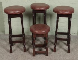 Four modern bar stools, topped with leatherette seat. Three taller and one small example.