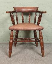 A smoker's bow armchair, with leather and studded base and back rest, turned supports and double