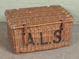 A large wicker basket stamped A.L.S to front with leather strap closures. Approx. dimensions 75cm