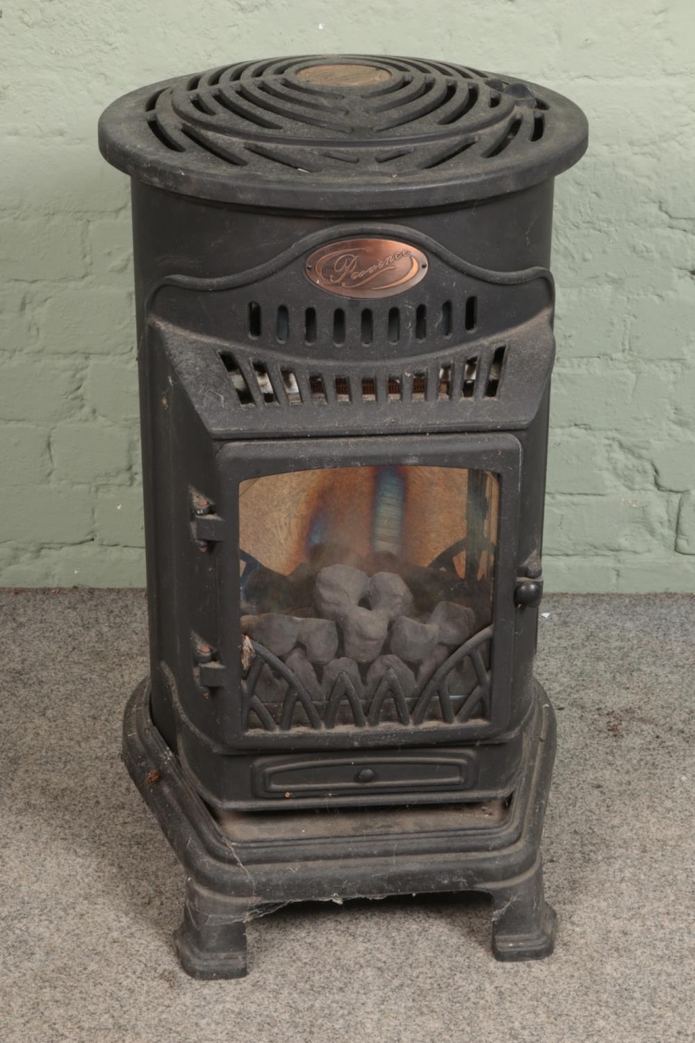 A Provence cast iron gas stove. Height 80cm, diameter 50cm. Bricks appear to be intact, glass