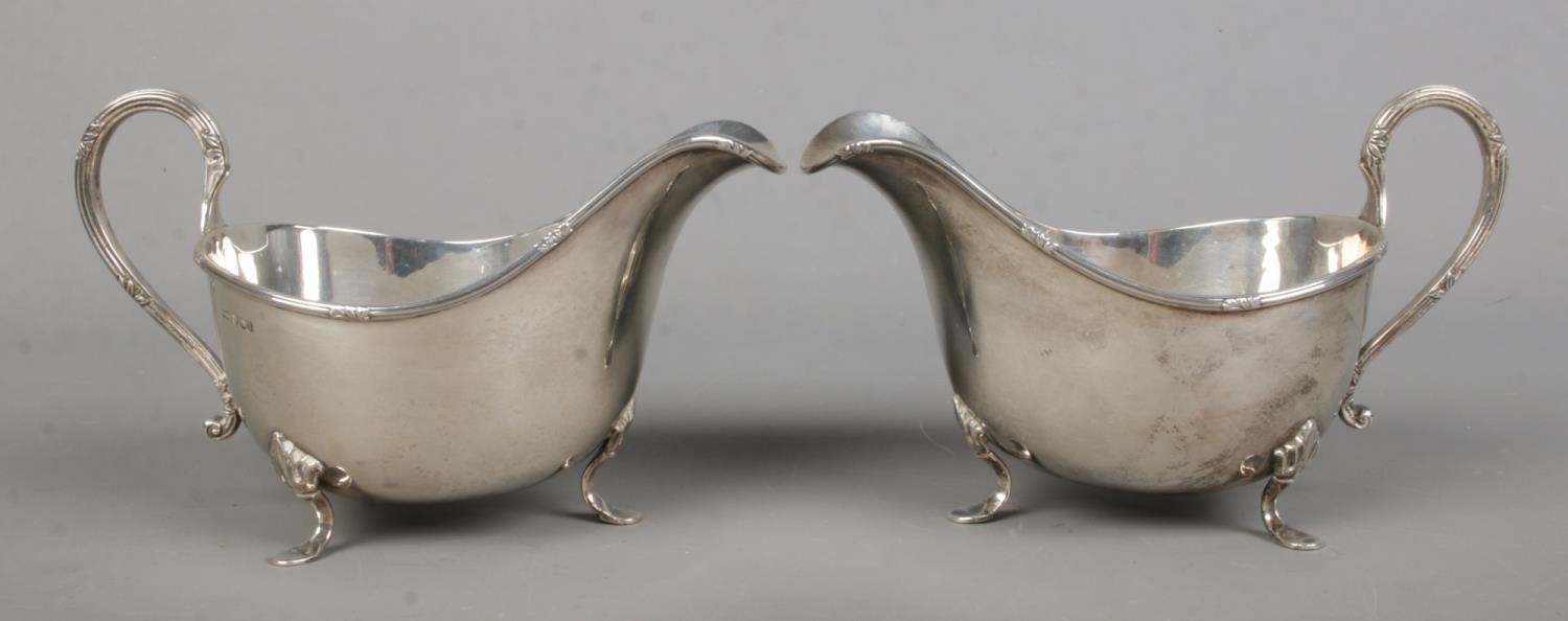 A pair of George V silver sauceboats, raised on three feet. Both assayed for Sheffield, 1928 by