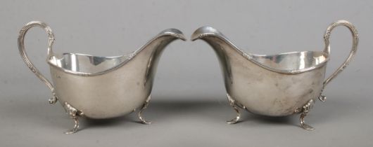 A pair of George V silver sauceboats, raised on three feet. Both assayed for Sheffield, 1928 by