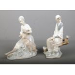 Two Nao by Lladro ceramic figures each depicting seated maidens interacting with animals.