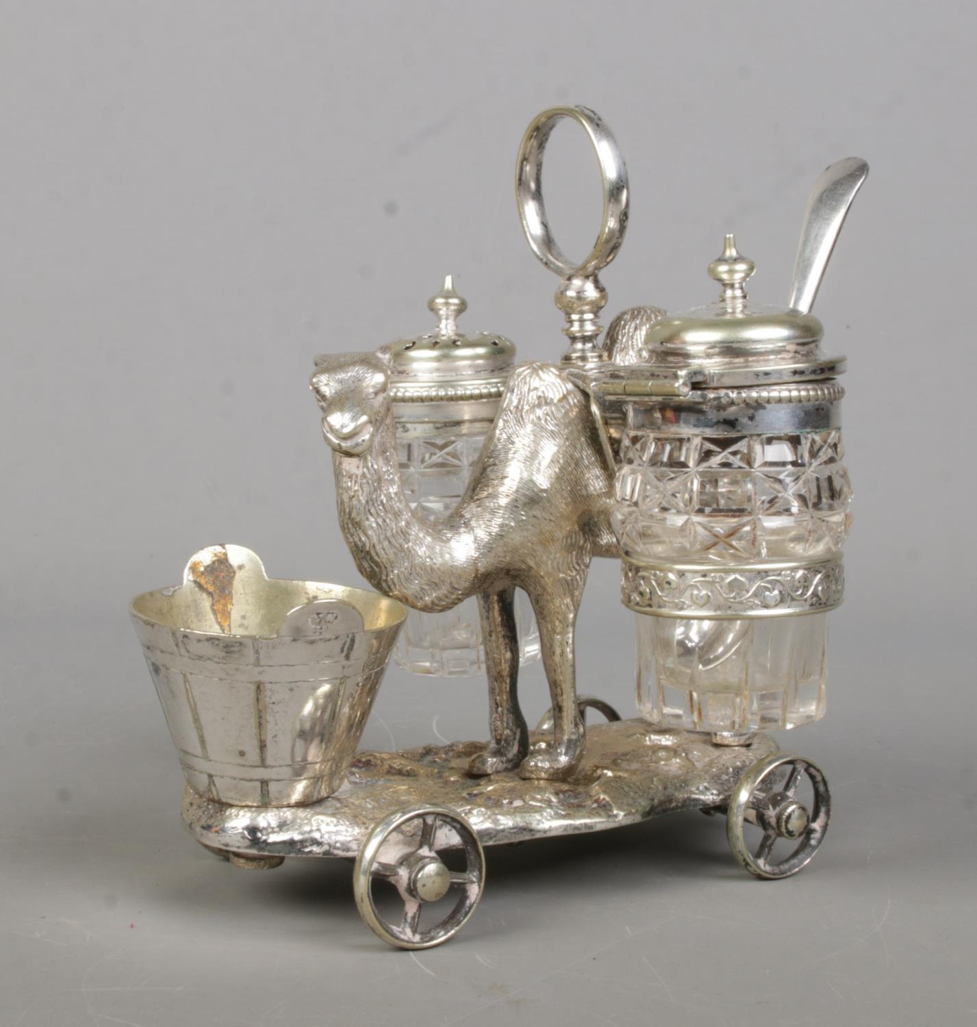 A Victorian novelty silver plated cruet set formed as a camel, with two glass panniers and bucket to