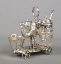A Victorian novelty silver plated cruet set formed as a camel, with two glass panniers and bucket to