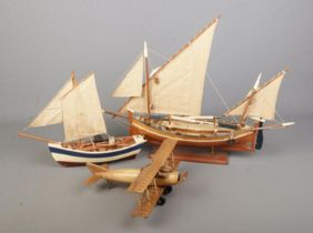 Three kit built model displays to include fishing boat on display stand and propellor plane.