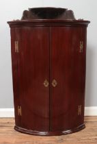 A mahogany bow fronted corner cupboard with upper tier. Height 102cm, Width: 68cm.