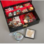 A jewellery case with contents of costume jewellery. Includes enamel earrings, simulated pearls,