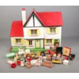A vintage two storey dolls house with furniture.