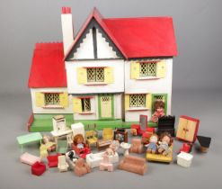 A vintage two storey dolls house with furniture.