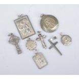 A collection of silver pendants. Includes five St Christopher examples and three cross examples.