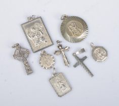 A collection of silver pendants. Includes five St Christopher examples and three cross examples.