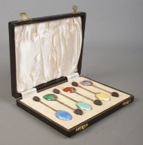 A boxed set of six silver and enamel coffee spoons, with bean finials, in fitted case. Assayed for