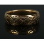 An 18ct Gold wedding band, with cross and dotted pattern. Size JÂ½. Total weight: 3.7g