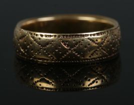 An 18ct Gold wedding band, with cross and dotted pattern. Size JÂ½. Total weight: 3.7g