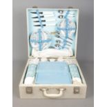 A vintage Brexton picnic hamper. Containing flasks, plates and cutlery. Appears complete, with key.