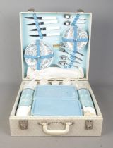 A vintage Brexton picnic hamper. Containing flasks, plates and cutlery. Appears complete, with key.